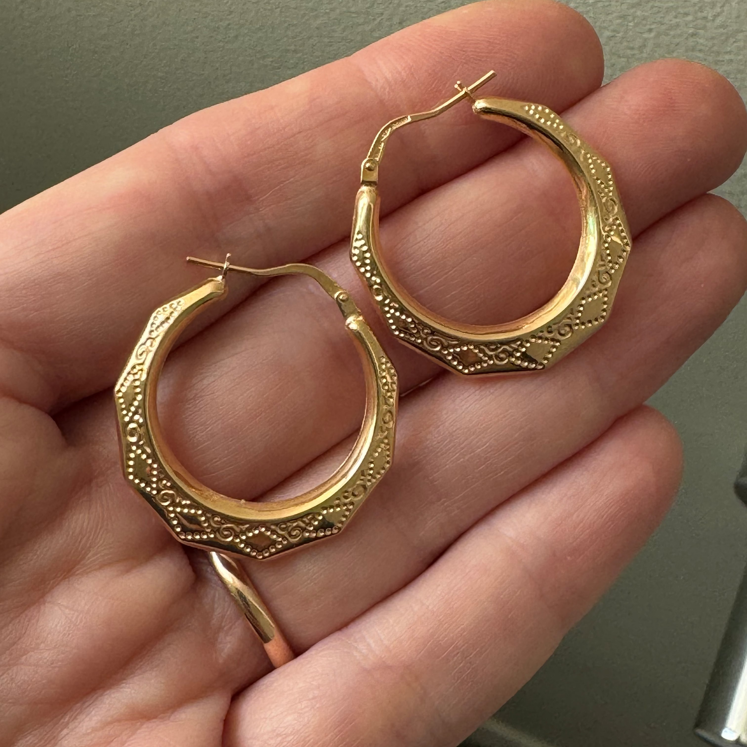 yellow gold hoops earrings with a pattern on the side