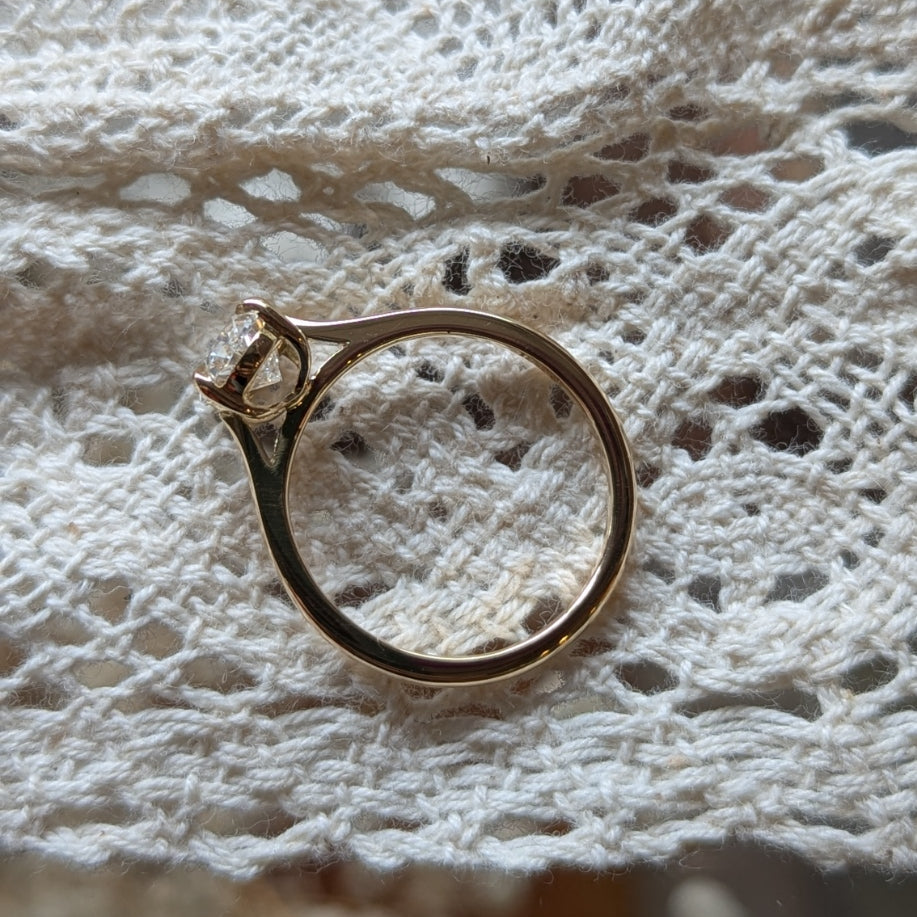 Gold ring on a textured white fabric background
